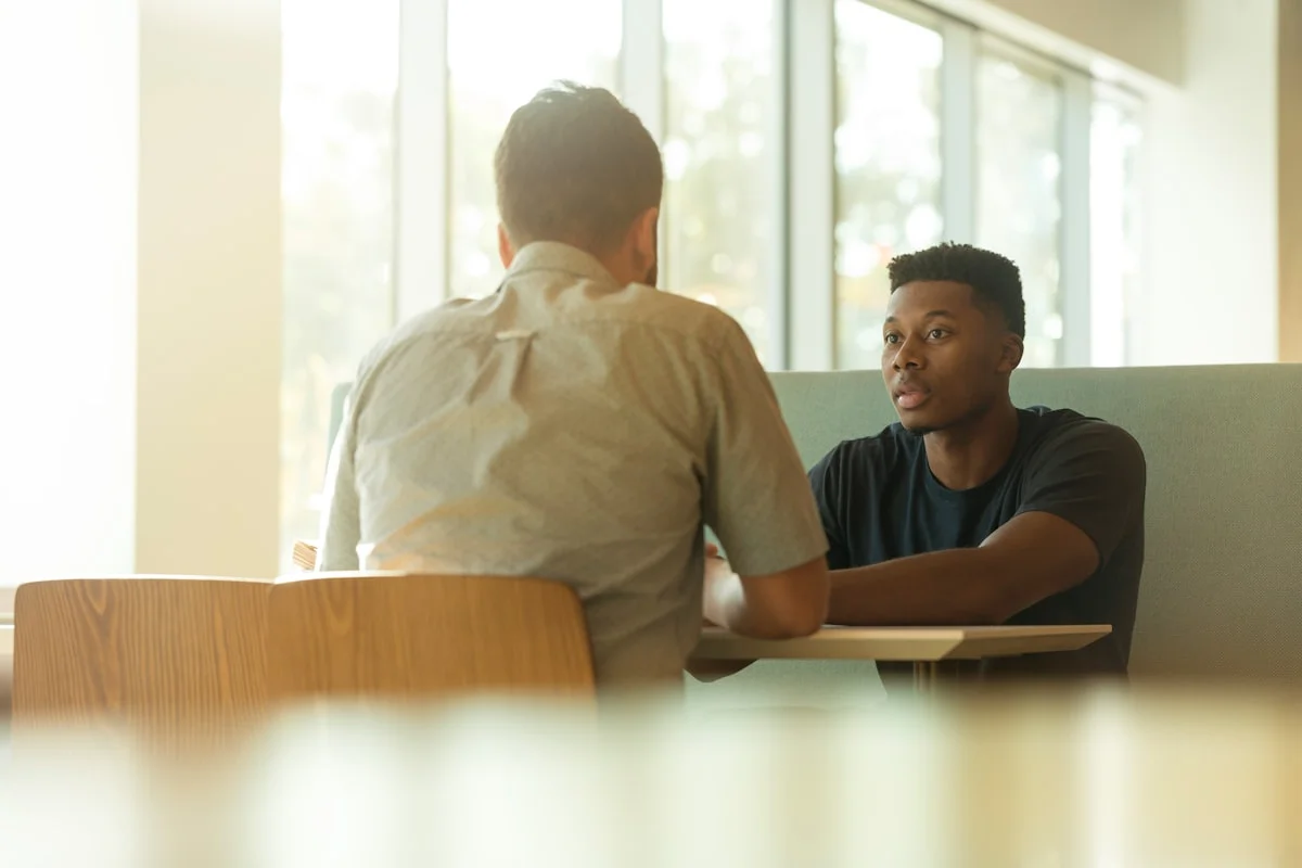 Two people in a focused face-to-face conversation, one listening intently